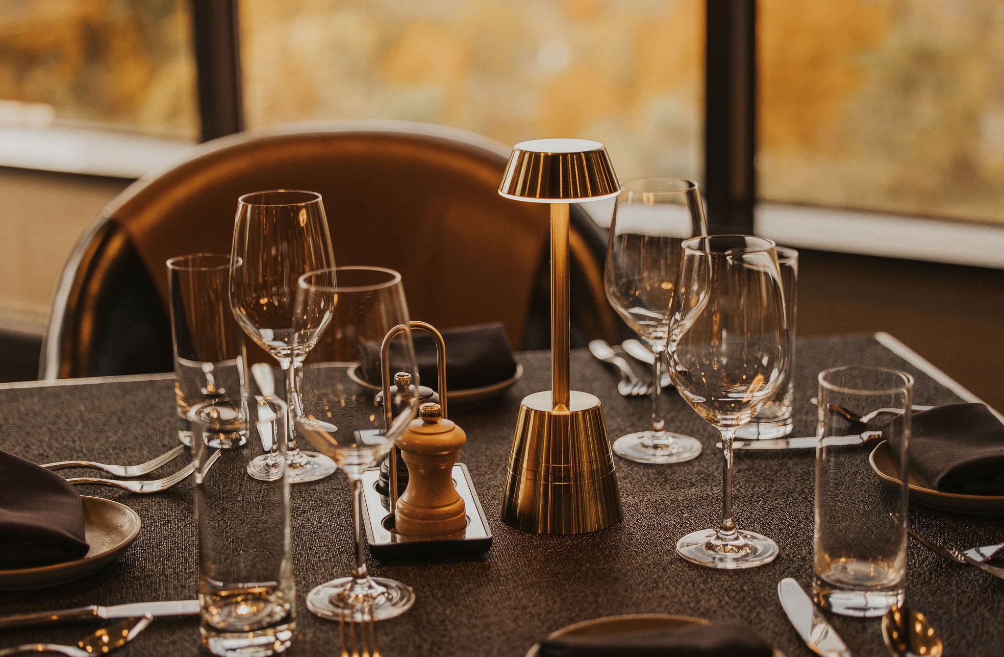 Horizons table setting in fall Table set for dinner at Horizons Modern Kitchen & Wine Bar with fall foliage through the windows