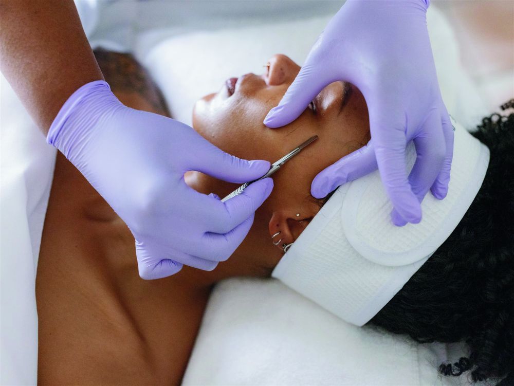 Esthetician performing a dermaplaning facial treatment at The Spa at Woodcliff